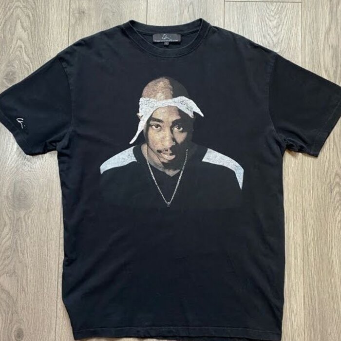 Vintage Tupac Shakur graphic t-shirt photographed on a dark wooden floor
